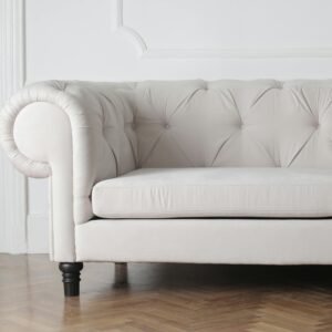 Luxurious white sofa in a modern minimalist interior with wooden flooring.